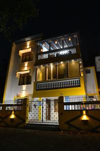 a building with a fence in front of it at night at La Maison Mira in Pondicherry