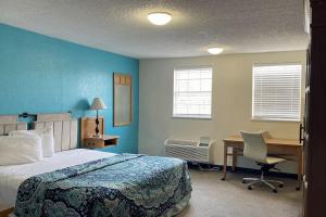 a bedroom with a bed and a desk with a computer at APM Inn & Suite in Jacksonville
