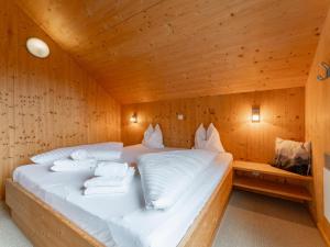 ein Bett in einem Holzzimmer mit Handtüchern darauf in der Unterkunft Die Bergliebe in Hohentauern