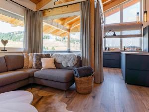 a living room with a couch and a large window at Grebenzen Lodge 1028 in Sankt Lambrecht