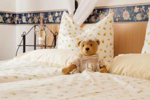 a teddy bear sitting on top of a bed at Hotel Goldenes Faß in Würzburg