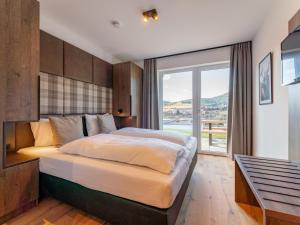a bedroom with a large bed and a large window at Grebenzen Lodge 1028 in Sankt Lambrecht