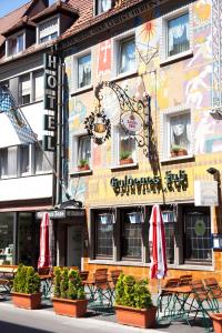 a building with chairs and umbrellas in front of it at Hotel Goldenes Faß in Würzburg