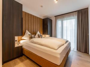 a bedroom with a large bed and a window at Grebenzen Lodge Edelblick in Sankt Lambrecht