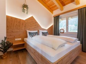 a bedroom with a large white bed in front of a window at Grebenzen Lodge Edelweiss in Sankt Lambrecht