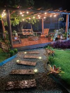 a backyard with a patio with lights and a deck at Pousada Vale das Pedras 03 in Pedras Grandes
