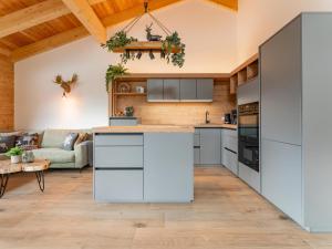 a kitchen with white cabinets and a living room at Grebenzen Lodge Edelweiss in Sankt Lambrecht