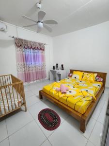 a bedroom with a yellow bed and a crib at villa Moissuli par chambre in Mtsamboro