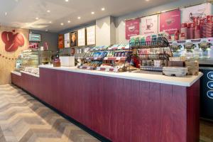 a store with a counter with food on it at Hilton London Olympia in London