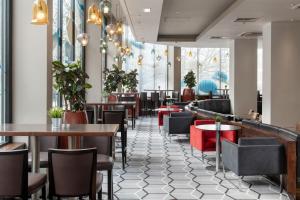 a dining room with tables and chairs at Hilton London Olympia in London