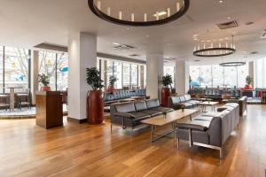 a lobby with couches and tables in a building at Hilton London Olympia in London