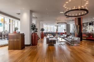a lobby with couches and chairs in a building at Hilton London Olympia in London +120 photos