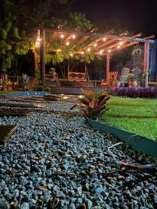 a rock garden at night with a gazebo at Pousada Vale das Pedras 02 in Pedras Grandes