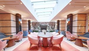 a lobby with tables and chairs and a fireplace at Conrad London St James in London