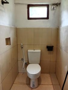 a small bathroom with a toilet and a window at Benang Kelambu Cottage in Praya +64 photos