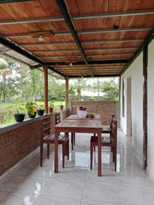 an outdoor patio with a wooden table and chairs at Benang Kelambu Cottage in Praya