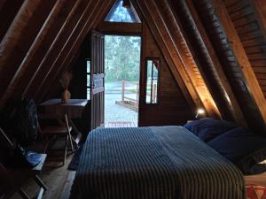 a bedroom with a bed in a wooden cabin at Pousada Vale das Pedras 02 in Pedras Grandes