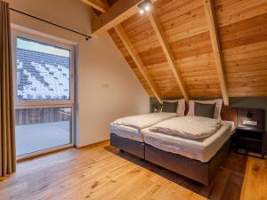 a bedroom with a bed and a large window at Mountain Chalet Aquarius 5A in Sankt Lorenzen ob Murau