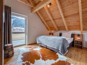 a bedroom with a bed and a large window at Mountain Chalet Esttes in Sankt Lorenzen ob Murau