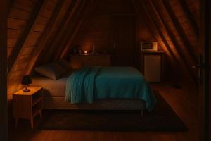 a bedroom with a bed with a blue blanket on it at Pousada Vale das Pedras 02 in Pedras Grandes