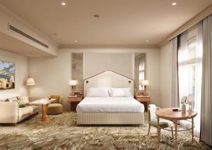 a bedroom with a bed and a couch and a table at The Waldorf Hilton in London