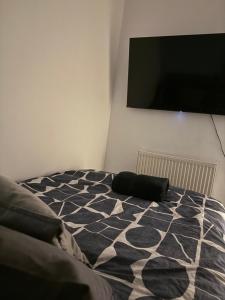 a bedroom with a bed and a flat screen tv at City Apartment in Litherland