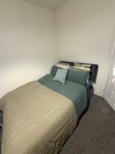 a bedroom with a large bed with blue pillows at City Apartment in Litherland