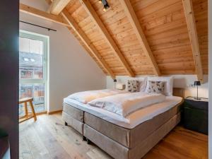a large bed in a room with a wooden ceiling at Mountain Chalet Berg-Glück in Sankt Lorenzen ob Murau