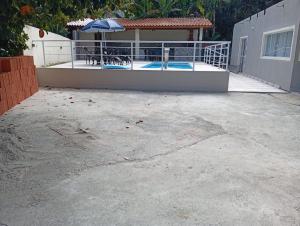 a patio with a swimming pool and a house at Acomodações Souza in Ilhabela