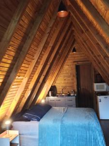 a bedroom with a bed in a wooden ceiling at Pousada Vale das Pedras 01 in Pedras Grandes