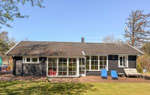 a small house with two blue chairs in the yard at Amazing Home In Græsted With Wifi in Græsted +14 photos