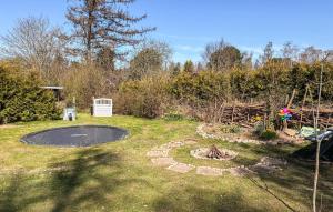 a backyard with a trampoline in the grass at Amazing Home In Græsted With Wifi in Græsted