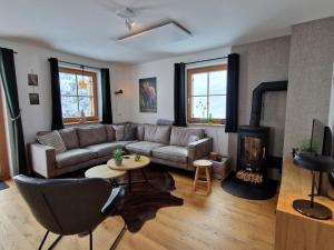 a living room with a couch and a fireplace at Sperlingnest in Donnersbachwald
