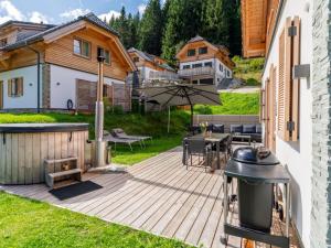 a backyard with a wooden deck with a grill at Haus Liene in Donnersbachwald