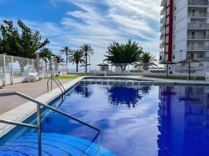 a large swimming pool with a building in the background at Nereidas Beachfront in Cullera
