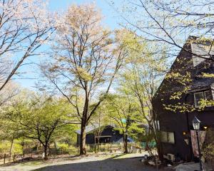 a black house with trees in the background at Nikko TEN Stay in Nikko