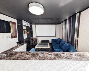 a living room with a blue couch and a white screen at Nikko TEN Stay in Nikko