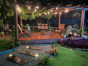 a garden at night with a pergola with lights at Cabana Vale das Pedras in Pedras Grandes