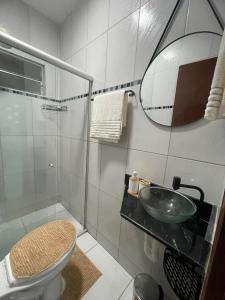 a bathroom with a sink and a toilet and a mirror at Apto do xavier III in Petrolina