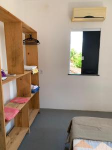 a bedroom with wooden shelves and a window at Apartamento com Terraço na Gamboa do Morro in Cairu
