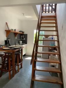 a wooden staircase in a room with a kitchen at Apartamento com Terraço na Gamboa do Morro in Cairu