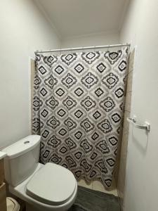 a bathroom with a toilet and a shower curtain at Island Ease Villa in Willemstad +7 photos