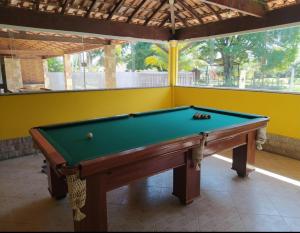 a pool table in a room with a yellow wall at Casa Shekinah in Araruama