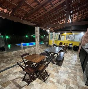 a patio with tables and chairs and a pool at Casa Shekinah in Araruama