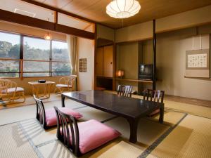 a living room with a dining room table and chairs at Ryotei Yamanoi in Matsue