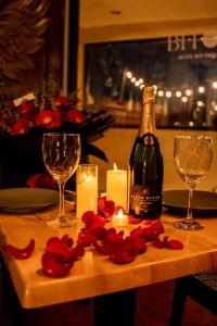 a table with a bottle of wine and candles and flowers at Hotel Bitos Boutique in San Miguel de Allende