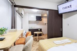 a small room with a bed and a dining room at Hopetree NambaImamiya in Osaka