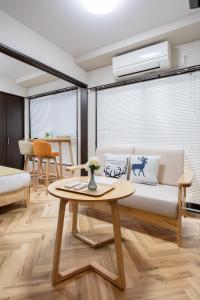 a living room with a couch and a table at Hopetree NambaImamiya in Osaka