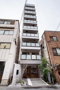 a tallartment building with a staircase leading up to it at Hopetree NambaImamiya in Osaka