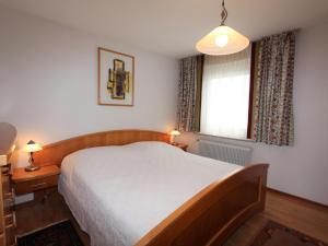 a bedroom with a large bed and a window at Mangartblick in Arriach